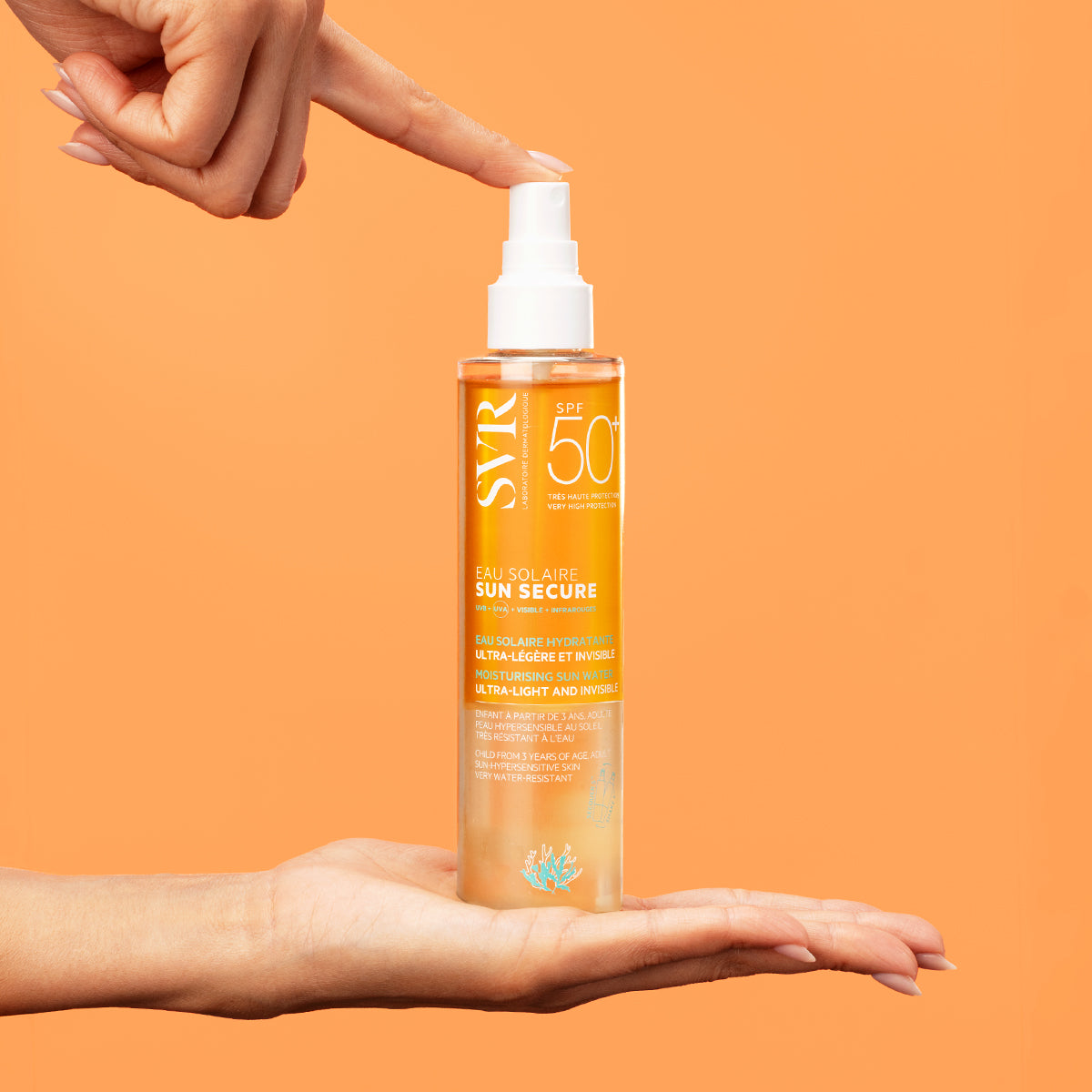 Spray SVR SUN SECURE Eau Solaire SPF50+ într-un flacon transparent cu textură bifazică, susținut între mâini pe fundal portocaliu.