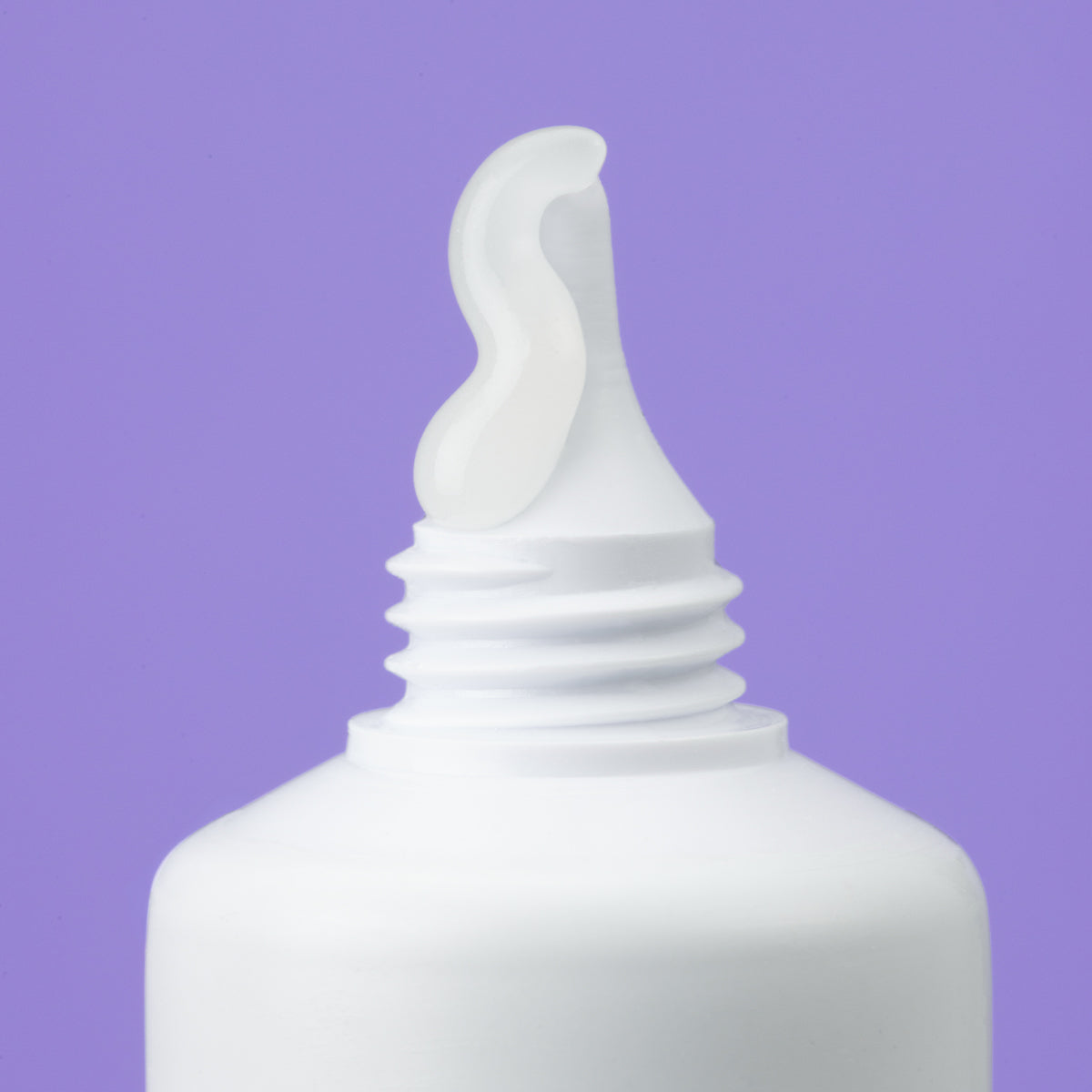 White tube of SEBIACLEAR Active Gel with a clear, smooth gel texture squeezed from the nozzle against a purple background.