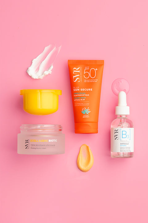 SVR skincare products including a firming cream, SPF 50 mousse, and B3 serum arranged on a bright pink background.